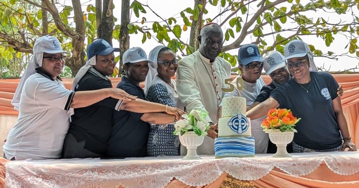 Sisters in Sierra Leone cutting the cake 