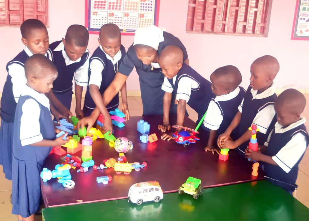 Children sorting through toys with teacher