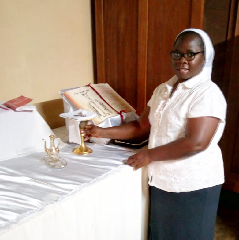 Sister assisting with communion distributionin sacristy during pandemic.