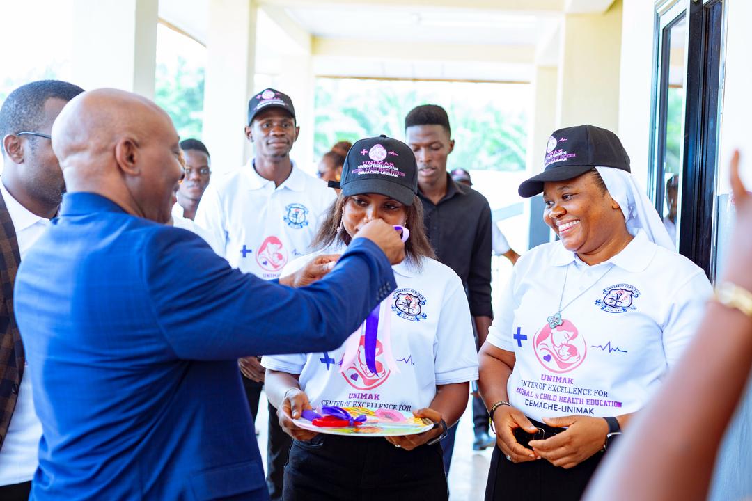 Sister Meg Umoh receives the key to the center of Excellence in Maternal and Child Health Education and Research, presented to her by the chairman of the board.